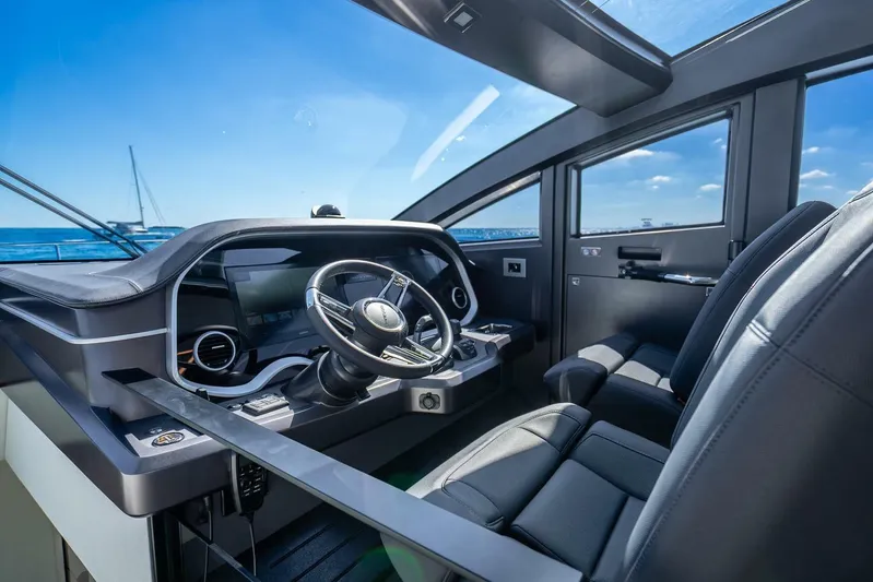  Yacht Photos Pics Interior of 2025 Pearl 63 yacht cockpit with modern steering and leather seats.