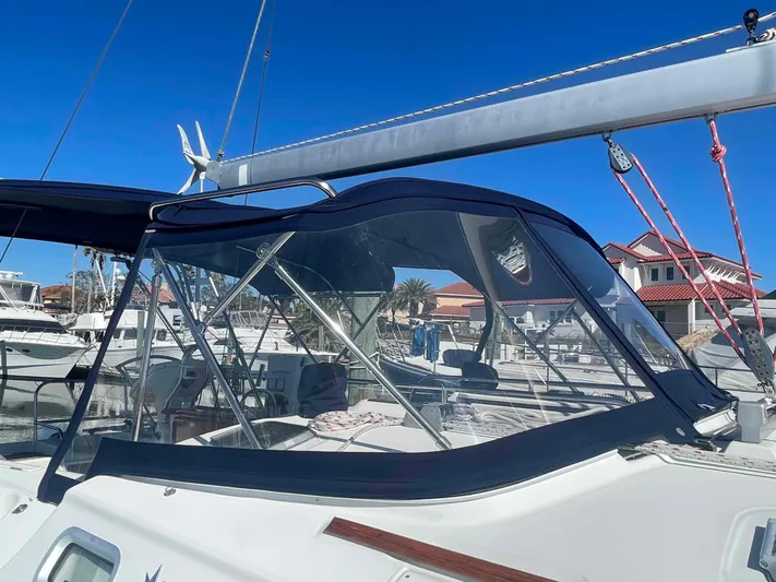 No Agenda Yacht Photos Pics 2003 Jeanneau Deck Salon sailboat with blue canopy in marina setting.