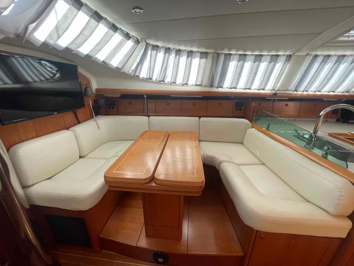 No Agenda Yacht Photos Pics 2003 Jeanneau Deck Salon interior with white seating and wooden table.