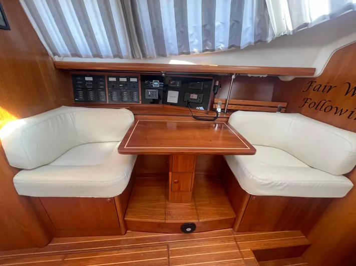 No Agenda Yacht Photos Pics 2003 Jeanneau Deck Salon interior with wooden table and cushioned seating.