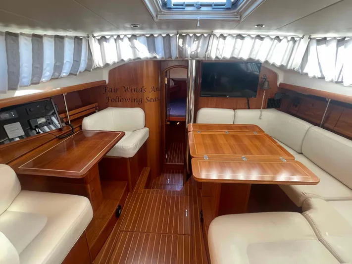 No Agenda Yacht Photos Pics 2003 Jeanneau Deck Salon interior with wood finish and cream seating.