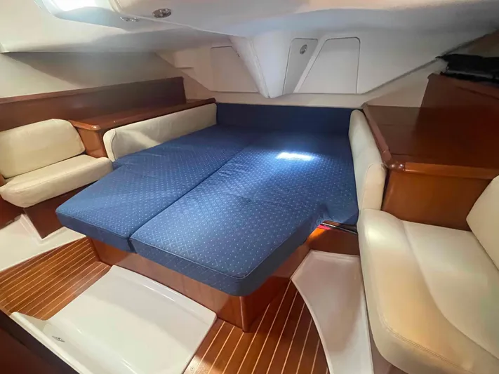 No Agenda Yacht Photos Pics 2003 Jeanneau Deck Salon interior with blue cushioned seating and wooden accents.