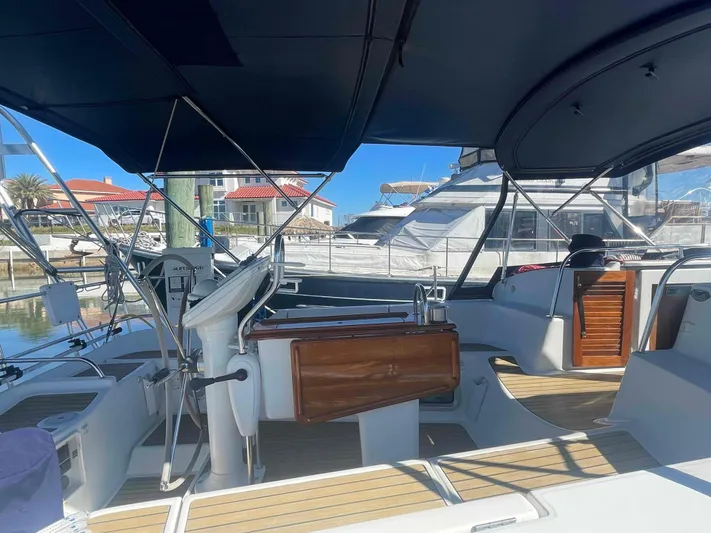No Agenda Yacht Photos Pics 2003 Jeanneau Deck Salon yacht interior with steering wheel, wooden accents, and marina view.