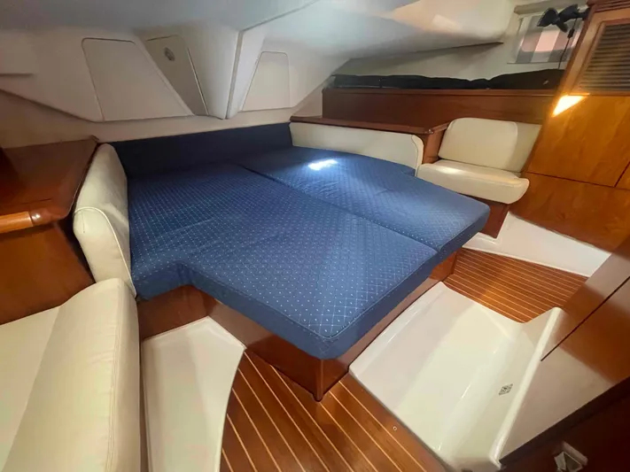 No Agenda Yacht Photos Pics 2003 Jeanneau Deck Salon interior with blue bedding and wooden accents.