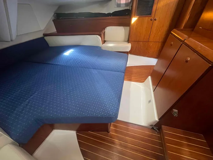 No Agenda Yacht Photos Pics 2003 Jeanneau Deck Salon interior with blue upholstery and wooden cabinetry.