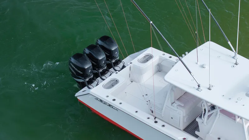  Yacht Photos Pics 2024 SeaHunter 35 Tournament boat with triple outboard engines on green water.