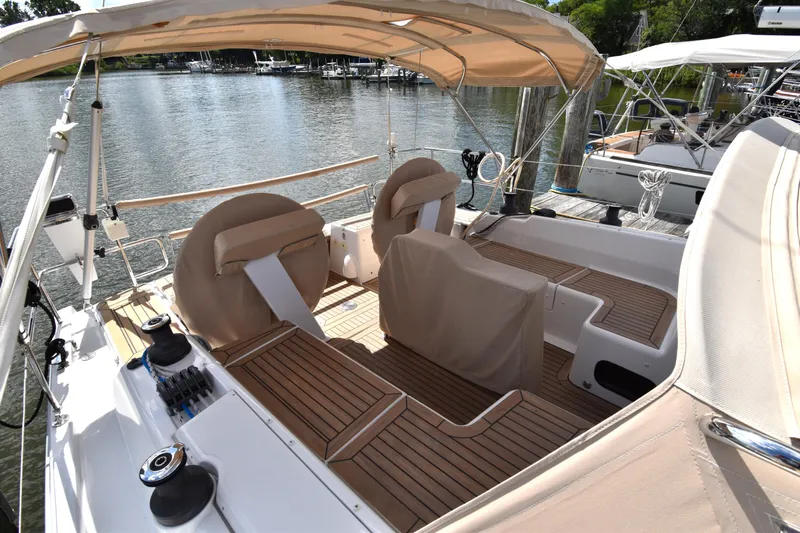 Maelynn Rose Yacht Photos Pics 2019 Hanse 458 yacht with teak deck and beige canopy docked by the water.