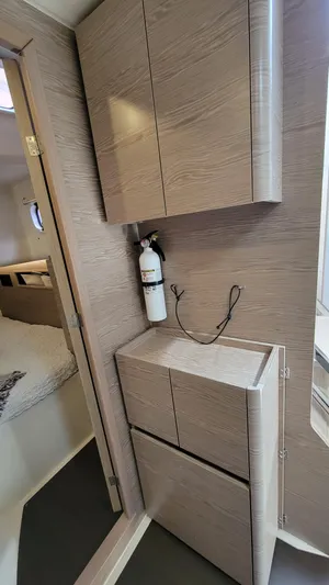 Maelynn Rose Yacht Photos Pics Interior of 2019 Hanse 458 yacht with modern wood cabinetry and fire extinguisher.