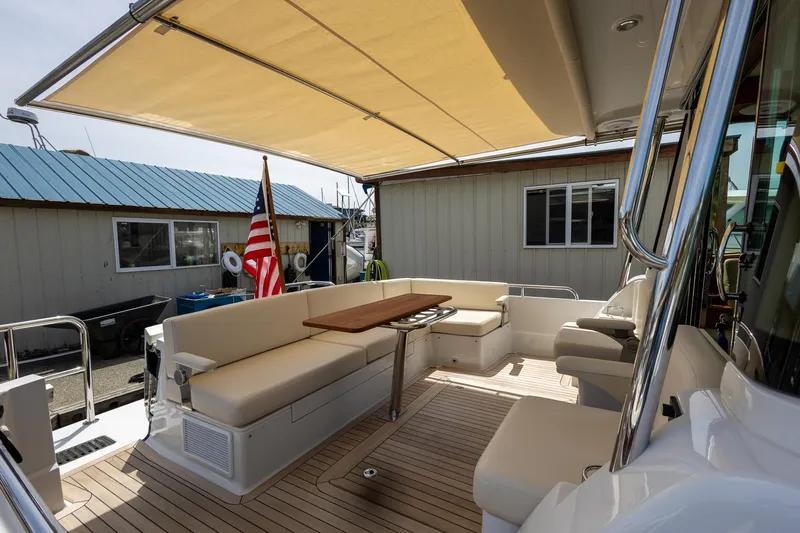 Luca Yacht Photos Pics 2023 Sabre 43 Salon Express yacht with shaded outdoor seating area and wooden table.