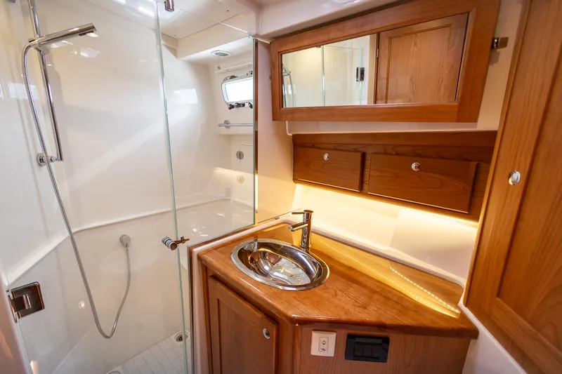 Luca Yacht Photos Pics 2023 Sabre 43 Salon Express bathroom with wooden cabinetry and modern fixtures.