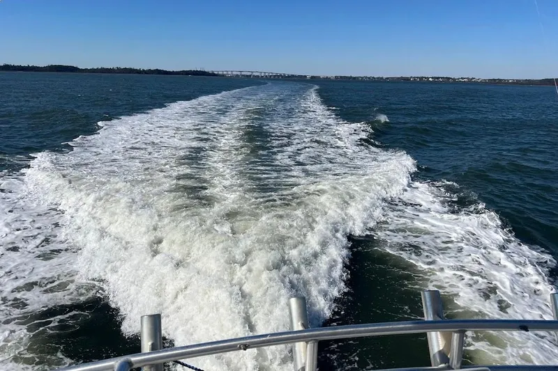 Reel Interest Yacht Photos Pics Wake of 2002 Ocean Yachts 56 Super Sport on open water, clear sky.