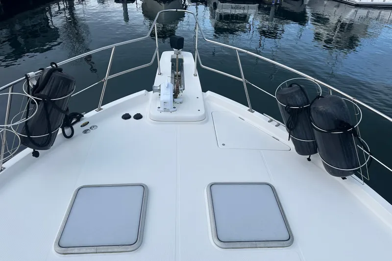 Stacey Lee Yacht Photos Pics 1999 Bayliner 4788 Pilot House Motoryacht bow with fenders and anchor, docked in marina.