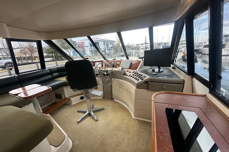 Stacey Lee Yacht Photos Pics 1999 Bayliner 4788 Pilot House Motoryacht interior with helm, seating, and panoramic windows.