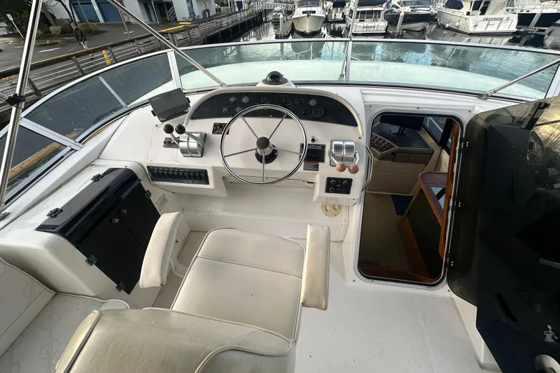 Stacey Lee Yacht Photos Pics 1999 Bayliner 4788 Pilot House Motoryacht helm with steering wheel and control panel.