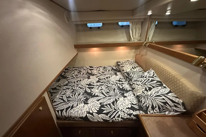 Stacey Lee Yacht Photos Pics 1999 Bayliner 4788 Pilot House Motoryacht bedroom with tropical bedding and cozy lighting.