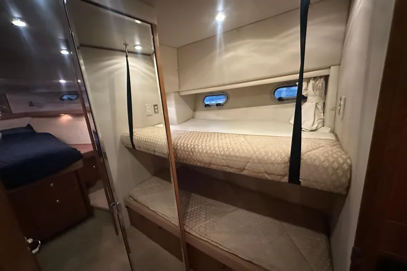 Stacey Lee Yacht Photos Pics 1999 Bayliner 4788 Pilot House Motoryacht interior with cozy bunk beds and porthole windows.