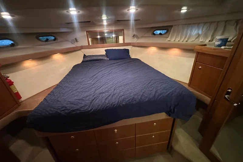Stacey Lee Yacht Photos Pics Luxurious bedroom in 1999 Bayliner 4788 Pilot House Motoryacht with cozy bedding and wooden cabinetry.
