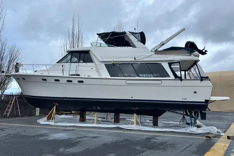 Stacey Lee Yacht Photos Pics 1999 Bayliner 4788 Pilot House Motoryacht on dry dock under cloudy sky.