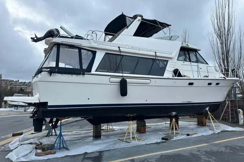 Stacey Lee Yacht Photos Pics 1999 Bayliner 4788 Pilot House Motoryacht on stands, overcast sky background.