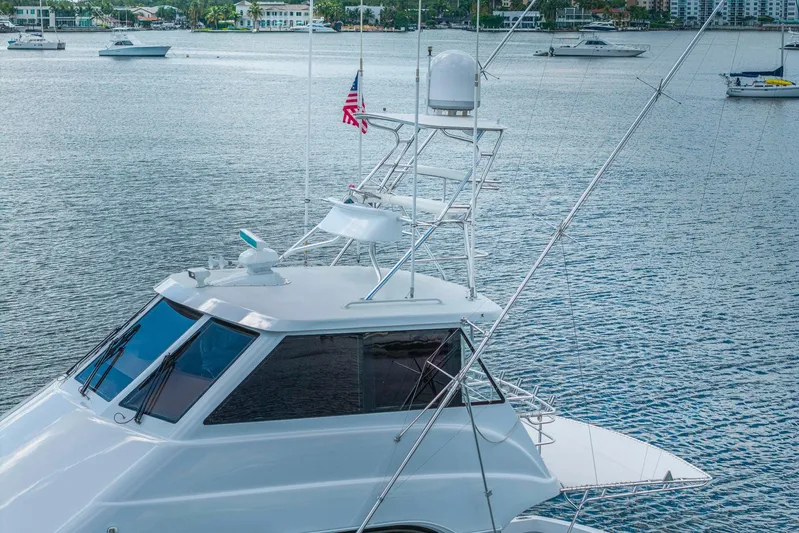 Sand Control Yacht Photos Pics 2002 Hatteras 60 Convertible yacht on calm water with other boats in background.