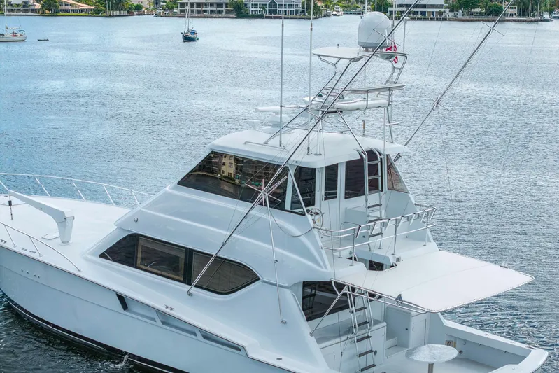 Sand Control Yacht Photos Pics 2002 Hatteras 60 Convertible yacht on serene water, showcasing sleek design and spacious deck.