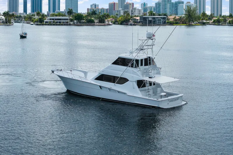 Sand Control Yacht Photos Pics 2002 Hatteras 60 Convertible yacht cruising near city skyline.