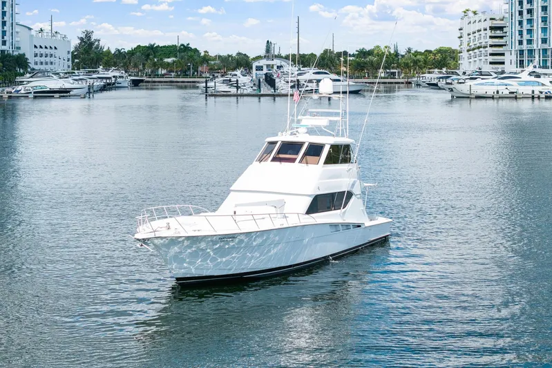 Sand Control Yacht Photos Pics 2002 Hatteras 60 Convertible yacht docked in a marina with surrounding boats.