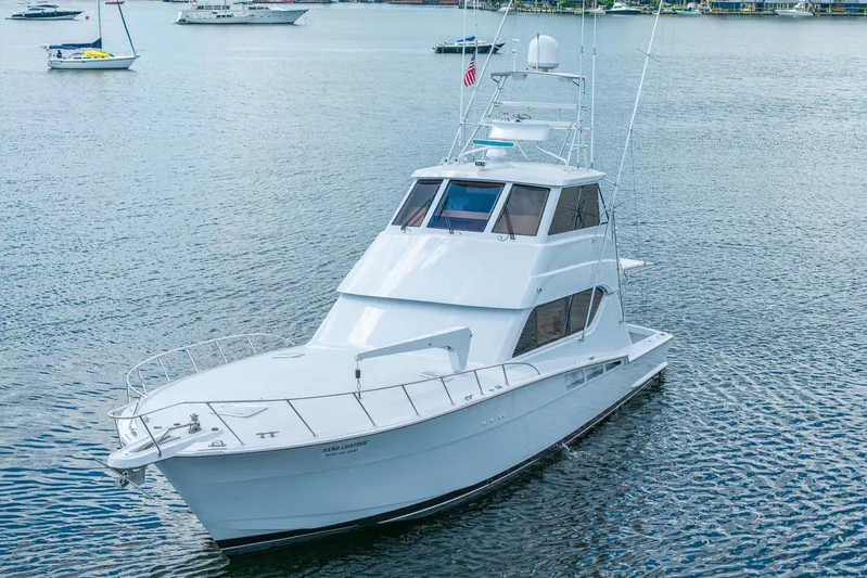 Sand Control Yacht Photos Pics 2002 Hatteras 60 Convertible yacht on calm water, showcasing sleek design and spacious deck.