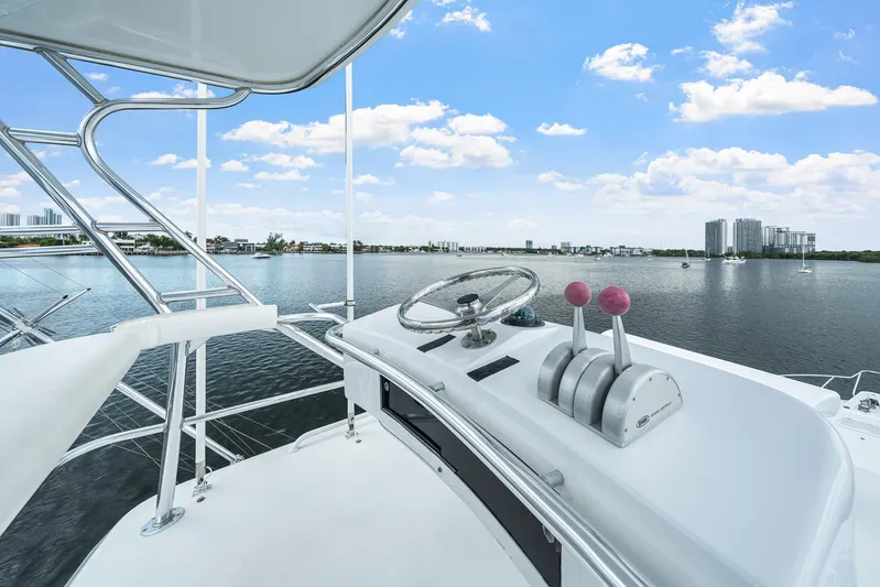 Sand Control Yacht Photos Pics Helm of 2002 Hatteras 60 Convertible yacht overlooking calm waters and city skyline.