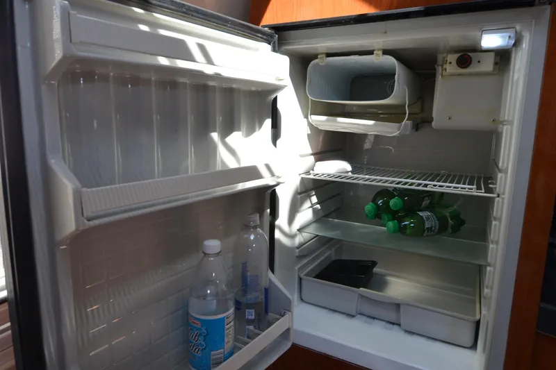  Yacht Photos Pics Open refrigerator inside 2006 Regal Commodore 3560 yacht, stocked with water and soda bottles.