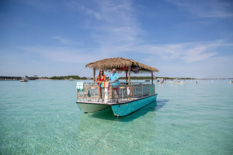 Big Kahuna Yacht Photos Pics 2022 Beachcat COI Tiki Boat on clear water under blue sky.