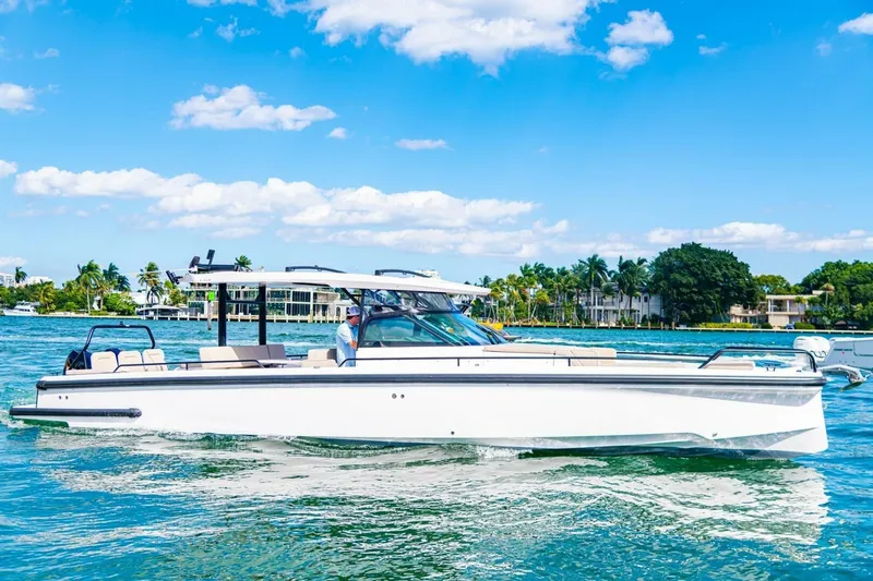 First Byte Yacht Photos Pics 2023 Axopar 37 Sun Top boat cruising on a sunny day with clear blue skies.