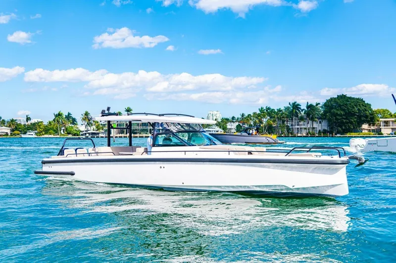 First Byte Yacht Photos Pics 2023 Axopar 37 Sun Top boat cruising on a sunny day, surrounded by tropical scenery.