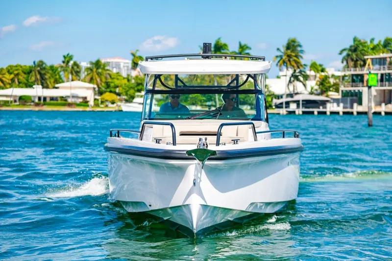 First Byte Yacht Photos Pics 2023 Axopar 37 Sun Top cruising on clear blue water, tropical backdrop.