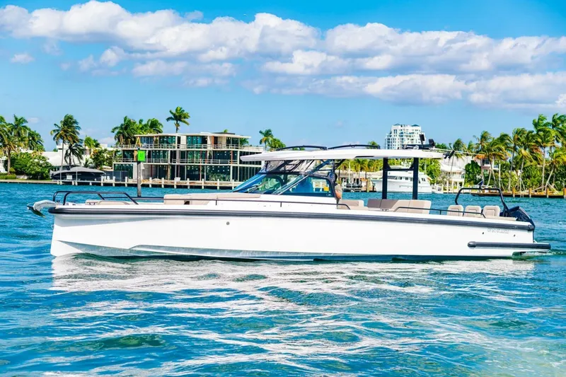 First Byte Yacht Photos Pics 2023 Axopar 37 Sun Top boat cruising on a sunny day with palm trees in the background.