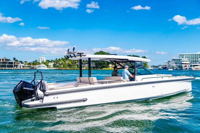 First Byte Yacht Photos Pics 2023 Axopar 37 Sun Top boat cruising on a sunny day with clear blue skies.