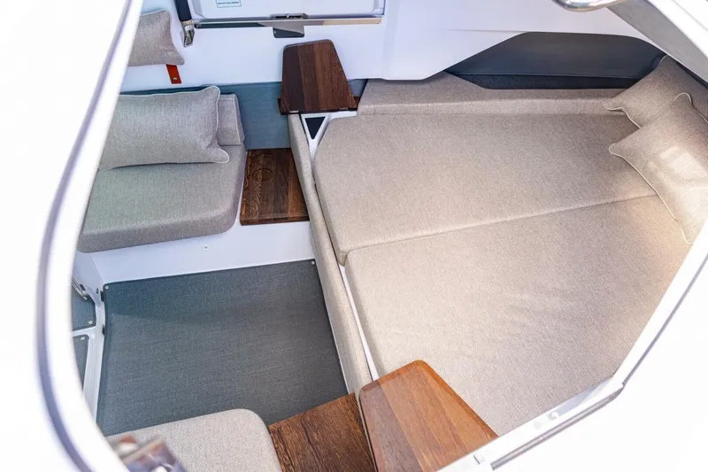 First Byte Yacht Photos Pics 2023 Axopar 37 Sun Top cabin interior with beige cushions and wooden accents.