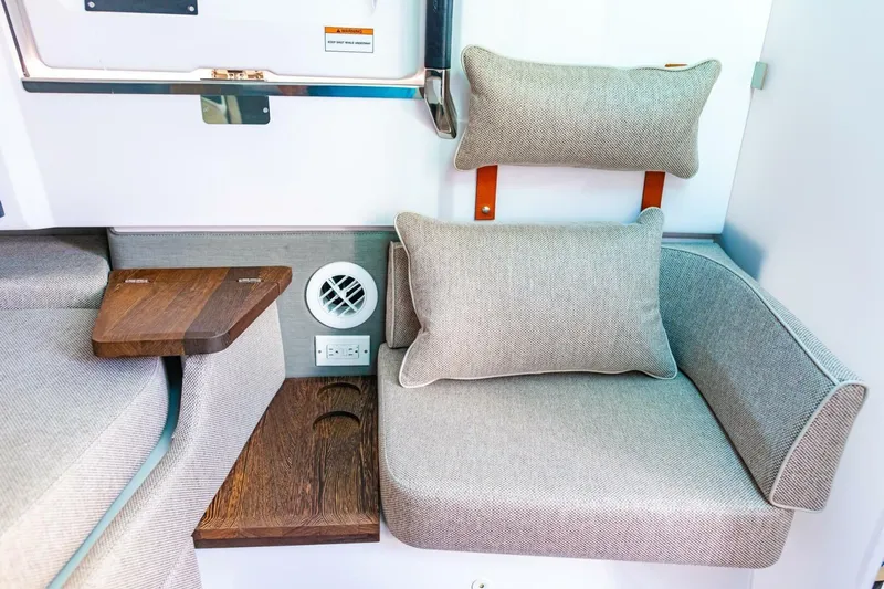 First Byte Yacht Photos Pics 2023 Axopar 37 Sun Top interior with cushioned seating and wooden accents.