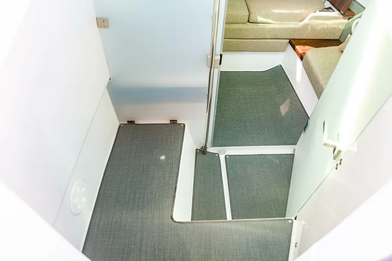 First Byte Yacht Photos Pics 2023 Axopar 37 Sun Top interior cabin with modern seating and carpeted flooring.