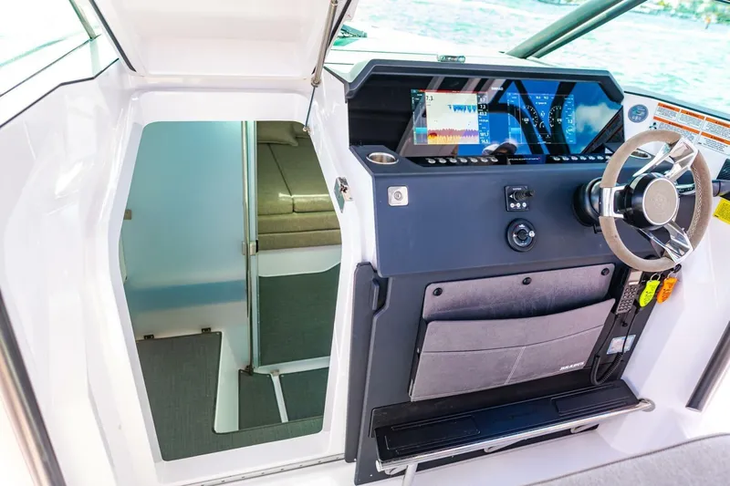 First Byte Yacht Photos Pics 2023 Axopar 37 Sun Top helm with modern controls and cabin entrance.