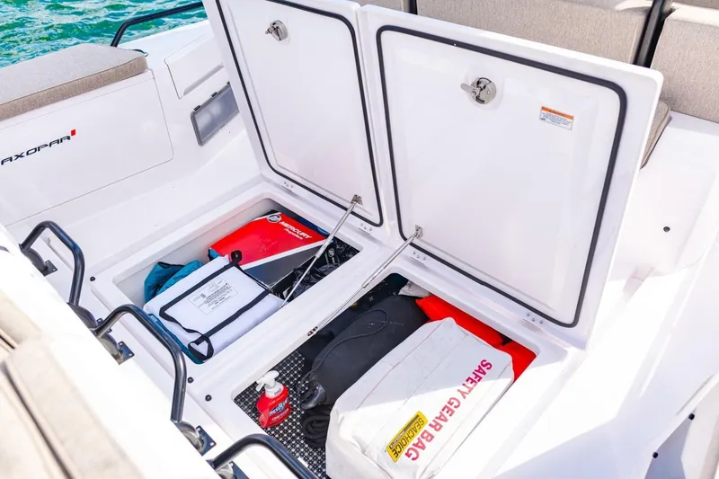 First Byte Yacht Photos Pics Open storage compartment on 2023 Axopar 37 Sun Top boat with safety gear and equipment.