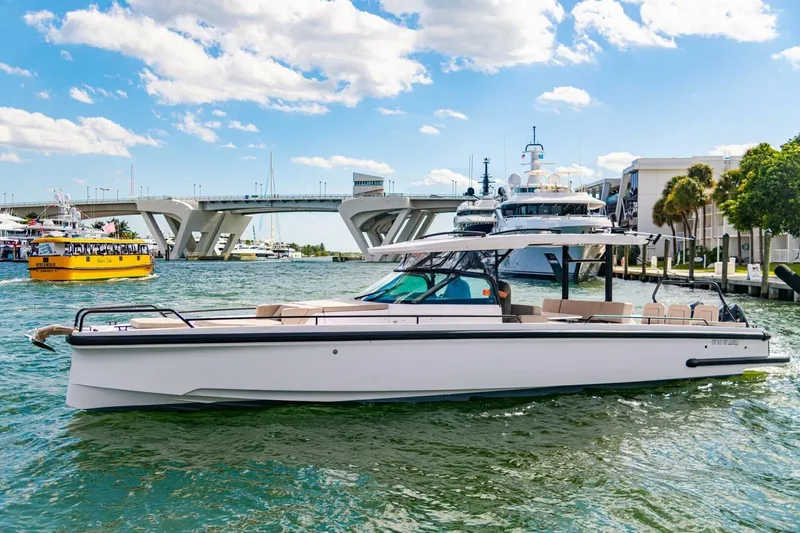 First Byte Yacht Photos Pics 2023 Axopar 37 Sun Top boat cruising near a bridge on a sunny day.