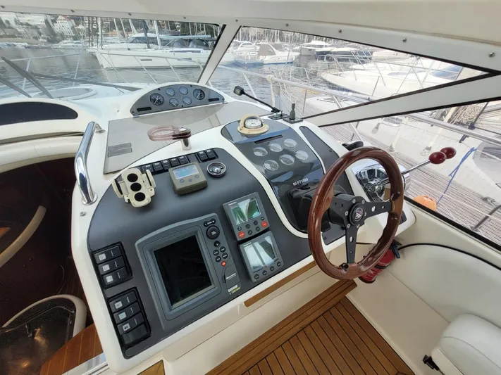Rmvca Yacht Photos Pics 2004 Fairline Targa 43 yacht helm with navigation controls and wooden steering wheel.