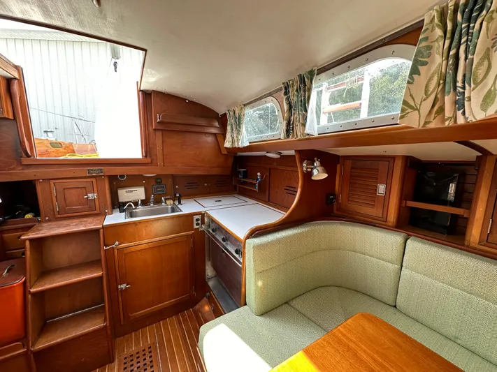  Yacht Photos Pics Interior of a 1978 Hinckley Bermuda 40 MK III sailboat with wood cabinetry and green seating.