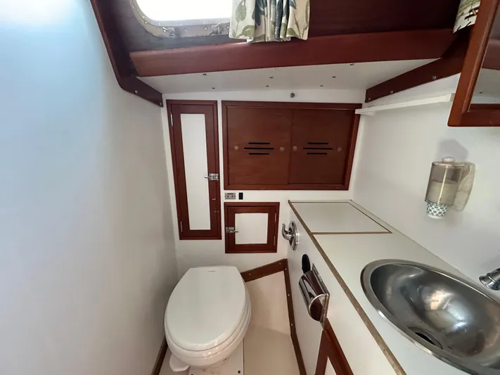  Yacht Photos Pics 1978 Hinckley Bermuda 40 MK III yacht bathroom with sink, toilet, and wooden cabinetry.