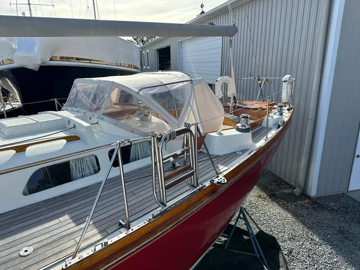  Yacht Photos Pics 1978 Hinckley Bermuda 40 MK III sailboat with red hull, docked near a metal building.