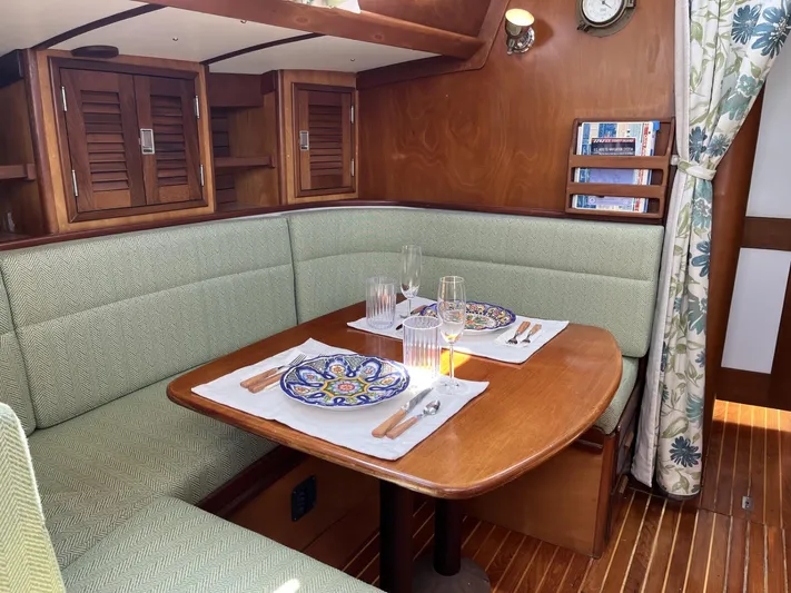  Yacht Photos Pics Cozy dining area in a 1978 Hinckley Bermuda 40 MK III sailboat, featuring elegant wood finishes.