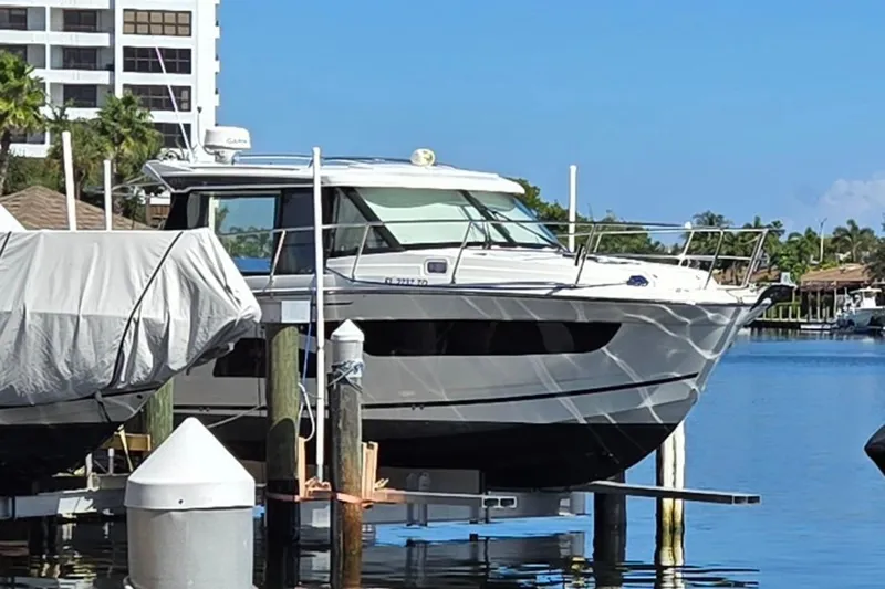  Yacht Photos Pics 2020 Jeanneau NC 1095 boat docked at a marina, surrounded by water and buildings.