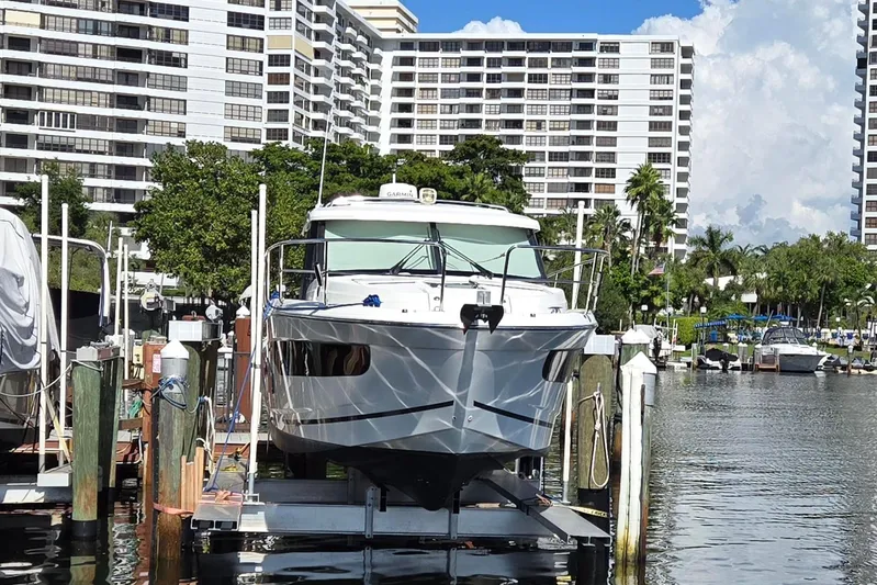  Yacht Photos Pics 2020 Jeanneau NC 1095 boat docked in marina with waterfront buildings.