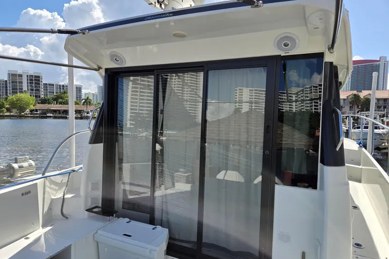  Yacht Photos Pics 2020 Jeanneau NC 1095 boat with sliding glass doors, docked in a marina.
